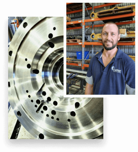 A photo of Brock Ryder, has a semi-bald haircurt and wears a dark blue polo shirt with the Logo of Ryder Machining Services. There are equipments and tools behind him. - Ryder Machining Specialists